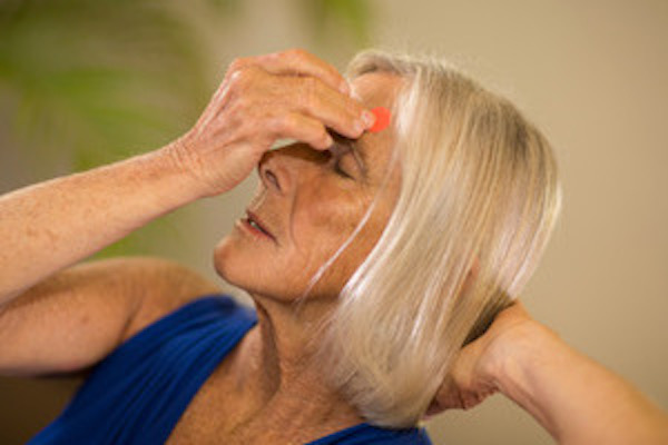 Woman holding acupressure points for self-acupressure.